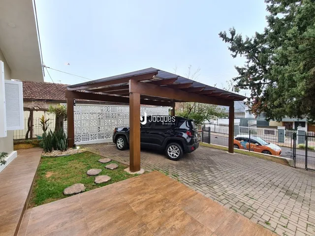 Vista da fachada de uma propriedade com estrutura de madeira e cerca branca.