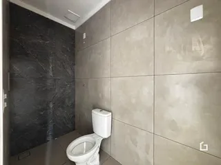Foto de um banheiro com revestimento de azulejos cinza e preto.