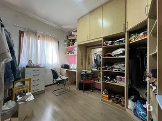 Quarto com armários embutidos e piso de madeira em uma residência.
