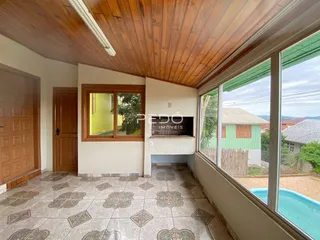 Vista interna de uma área com piso de cerâmica e teto de madeira.