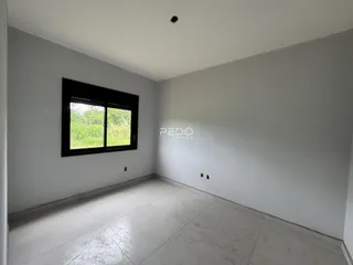 Foto de um cômodo interno com paredes brancas e piso de cerâmica.