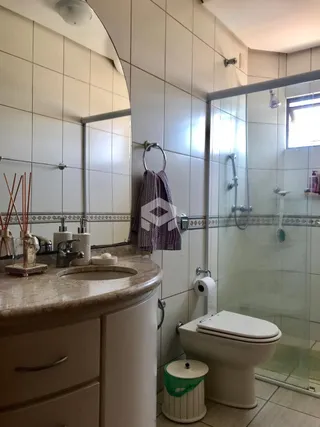 Foto de um banheiro com pia e box de vidro.