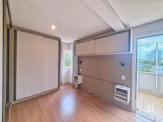 Vista interna de um ambiente com piso de madeira clara e paredes cinzas.