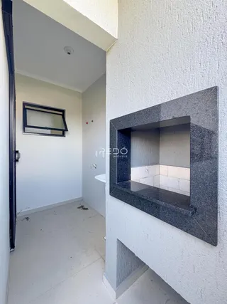 Fachada moderna de uma residência com um painel de pedra escura na parede externa.