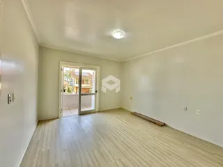 Sala de estar com piso de madeira clara e portas de vidro.