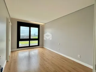 Sala de estar com piso de madeira e grande janela.