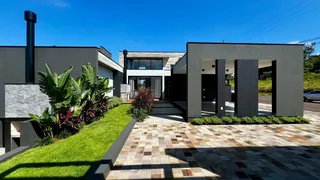 Fachada moderna de uma residência em Lajeado, Brasil, com paisagismo e área externa pavimentada.