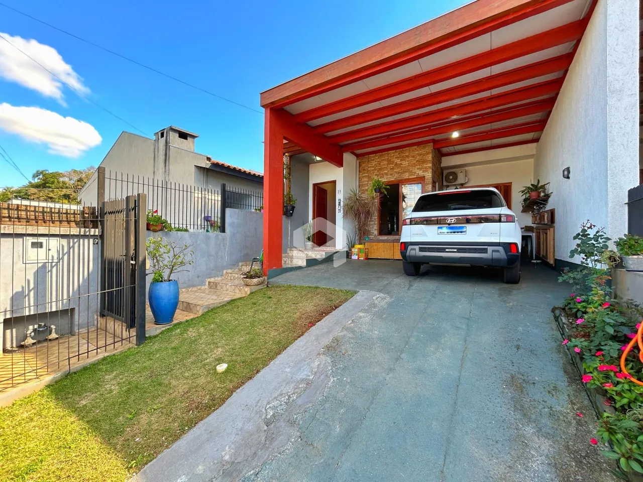 Fachada de uma casa em Lajeado, Brasil, com área coberta e jardim frontal.