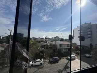 Vista externa de uma rua com carros estacionados e edifícios residenciais.
