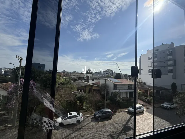 Vista externa de uma rua com carros estacionados e edifícios residenciais.