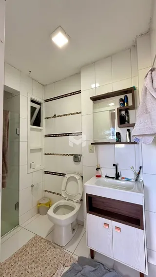 Foto de um banheiro interno com revestimento cerâmico branco.