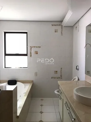A foto mostra o interior de um banheiro com revestimento branco.
