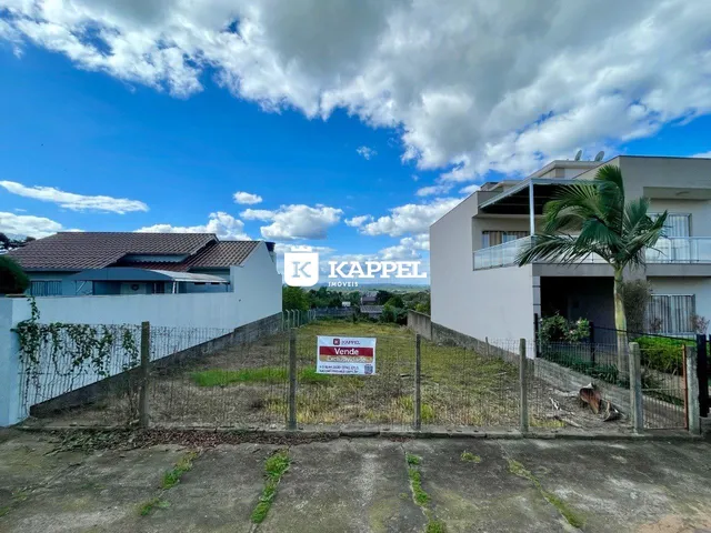 Fachada de uma casa moderna em Lajeado, Brasil, com cerca e vegetação no primeiro plano.