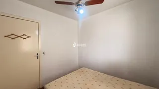 Quarto com cama e porta branca em uma residência.