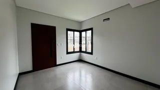 Interior de um cômodo com porta e janela em uma residência.