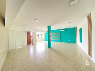 Ambiente interno de uma sala ampla com piso de cerâmica clara.