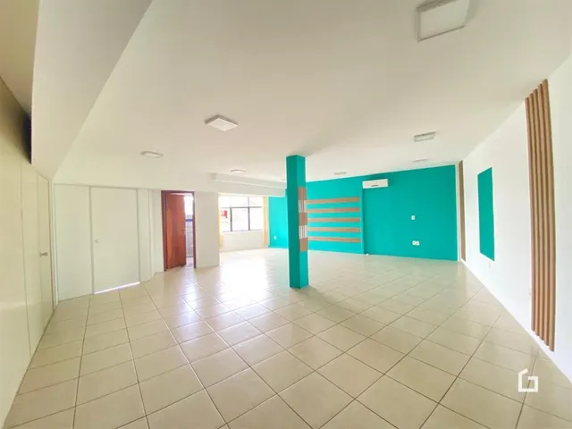 Ambiente interno de uma sala ampla com piso de cerâmica clara.