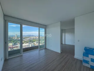 Sala de estar com vista panorâmica da cidade através de grandes portas de vidro.