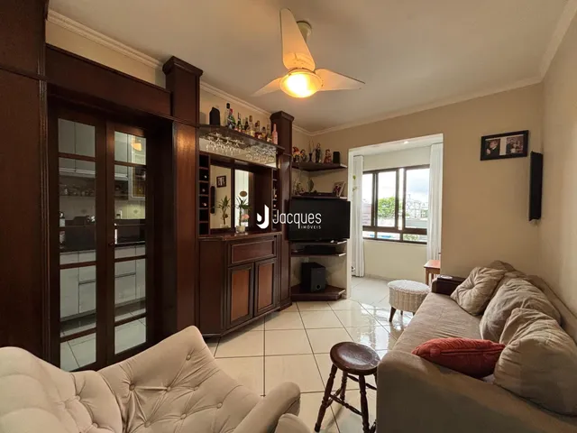 Sala de estar com móveis de madeira e sofá claro.