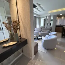 Sala de estar moderna com acabamentos claros.