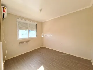 Foto de um cômodo interno com piso de madeira clara e paredes neutras.