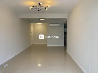 Hall de entrada com piso claro e iluminação central.