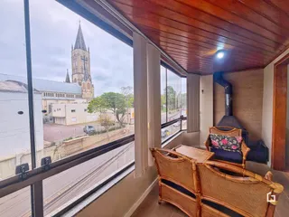 Vista da rua com igreja ao fundo de uma área interna.