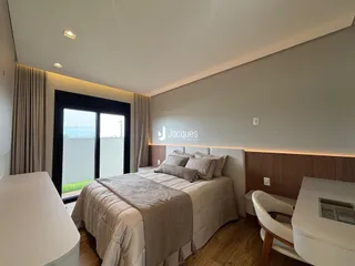 Quarto com cama e porta de vidro abrindo para o exterior.
