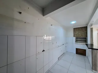 Vista de um corredor interno com paredes brancas e piso de cerâmica.