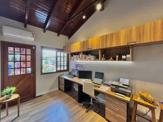 Ambiente interno de uma sala com forro de madeira e móveis planejados.