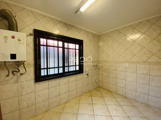 Interior de um ambiente com paredes de azulejo e uma janela.