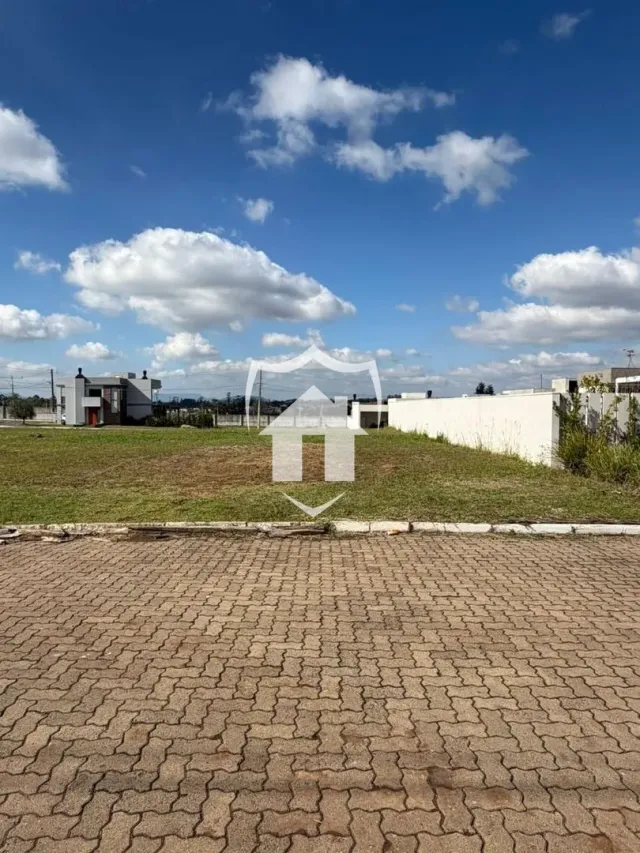 Vista externa de uma propriedade com gramado e pavimento de tijolos.