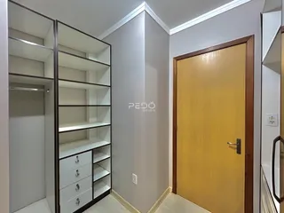 Foto de um corredor interno com estantes e uma porta de madeira.