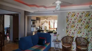 Sala de estar com sofá azul e decoração floral na parede.