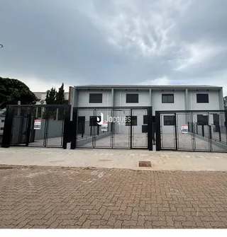 Fachada de uma residência com portão de ferro na rua.