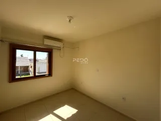 Vista interna de uma sala com piso de cerâmica e janela.
