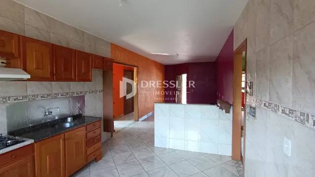 Foto da cozinha com armários de madeira e piso de cerâmica.