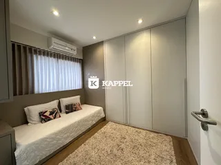 Quarto com cama de casal e armários em um ambiente com piso de madeira.