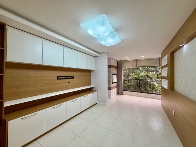 Vista de um corredor interno com revestimento de madeira e piso cerâmico claro.