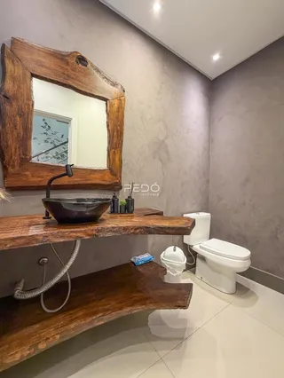 Banheiro com bancada de madeira rústica e piso claro.