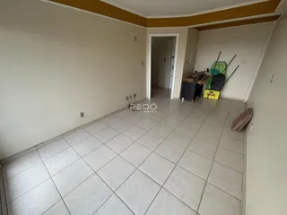 Vista de um corredor interno com piso de cerâmica clara.