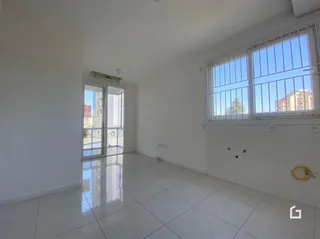Sala de estar com piso de cerâmica e grandes janelas.