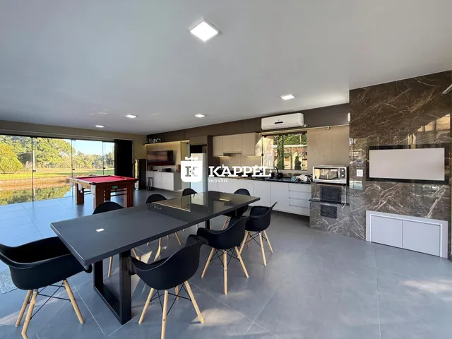 Uma sala de jantar moderna com grandes portas de vidro que dão acesso a uma área externa.
