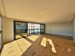 Vista interna de uma sala com portas de vidro voltadas para o exterior.