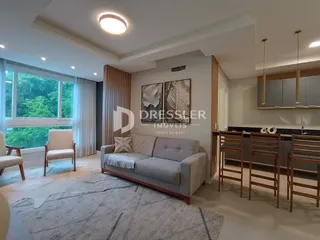Sala de estar com sofá e cadeiras em um ambiente claro.