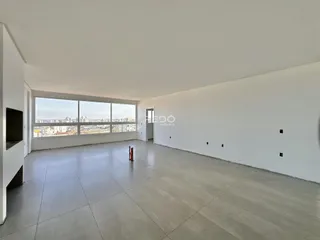 Ambiente interno de uma sala ampla com vista para a cidade.