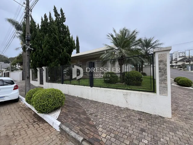 Fachada de uma residência em Lajeado, Brasil, com cerca e paisagismo.