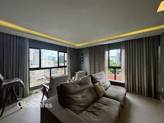 Sala de estar com vista para a cidade e grandes janelas.