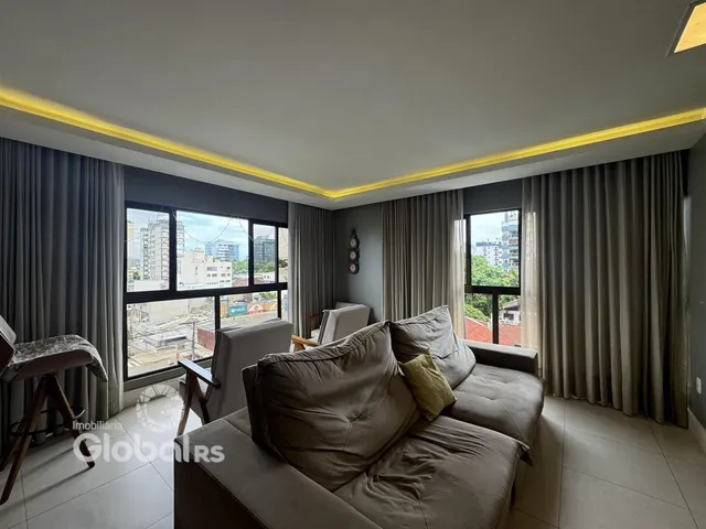 Sala de estar com vista para a cidade e grandes janelas.
