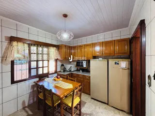 Foto de uma sala de jantar com armários de madeira e janela.